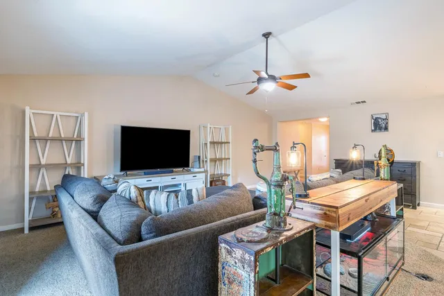 a living room with furniture a flat screen tv and a large window