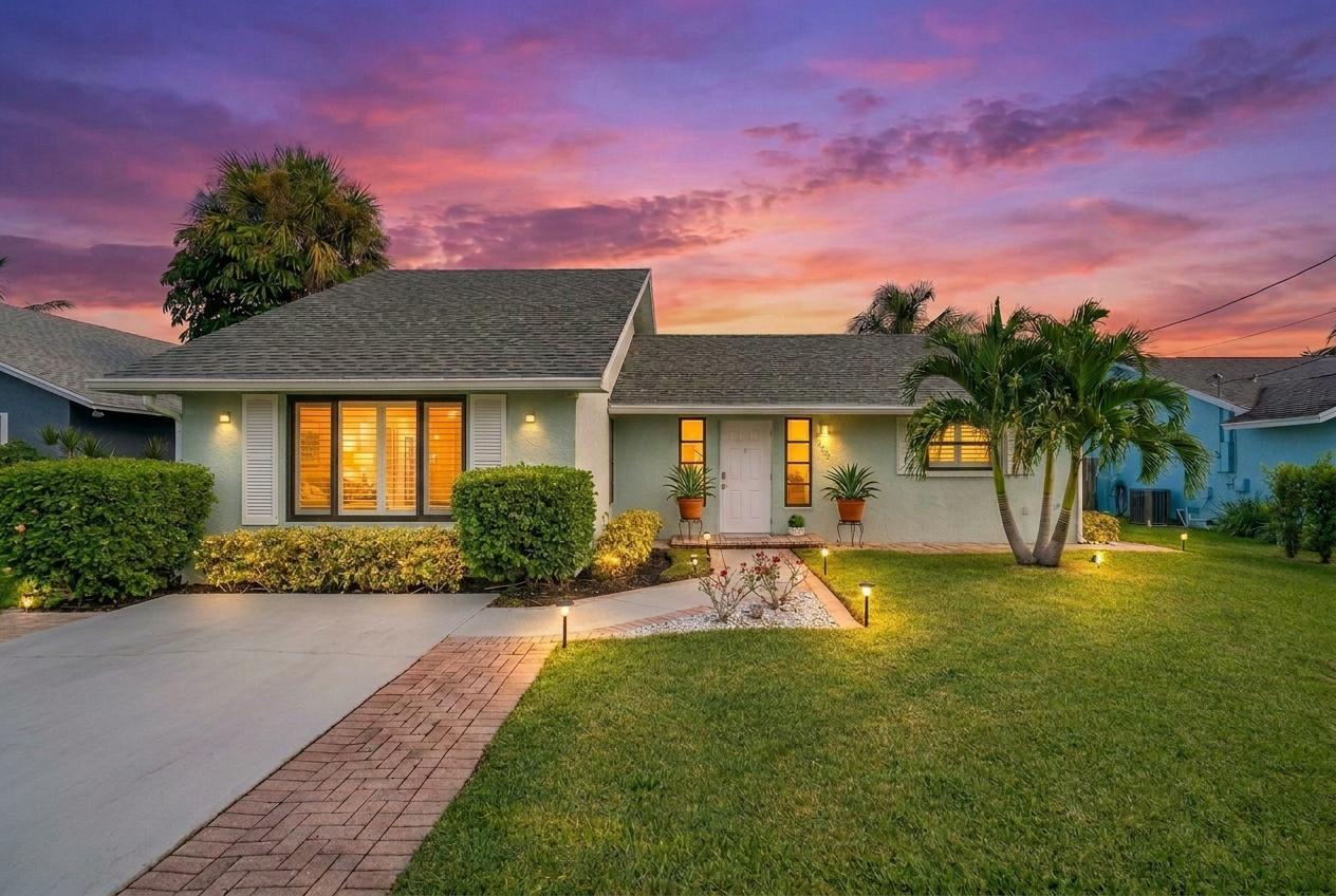 6085 Robinson Street Jupiter, FL 33458 - Photo 1 of 32 a front view of a house with a yard