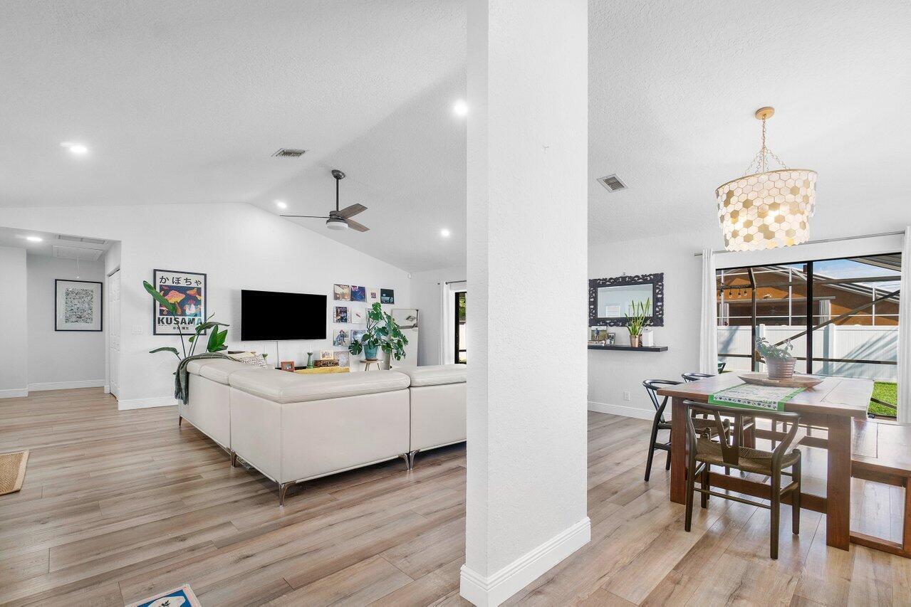 6085 Robinson Street Jupiter, FL 33458 - Photo 13 of 32 a living room with furniture a flat screen tv and a large window