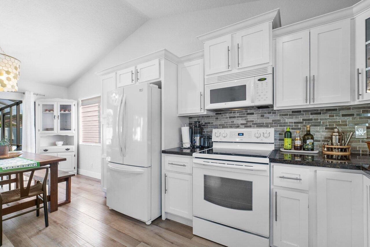 6085 Robinson Street Jupiter, FL 33458 - Photo 16 of 32 a kitchen with cabinets stainless steel appliances a sink and wooden floor