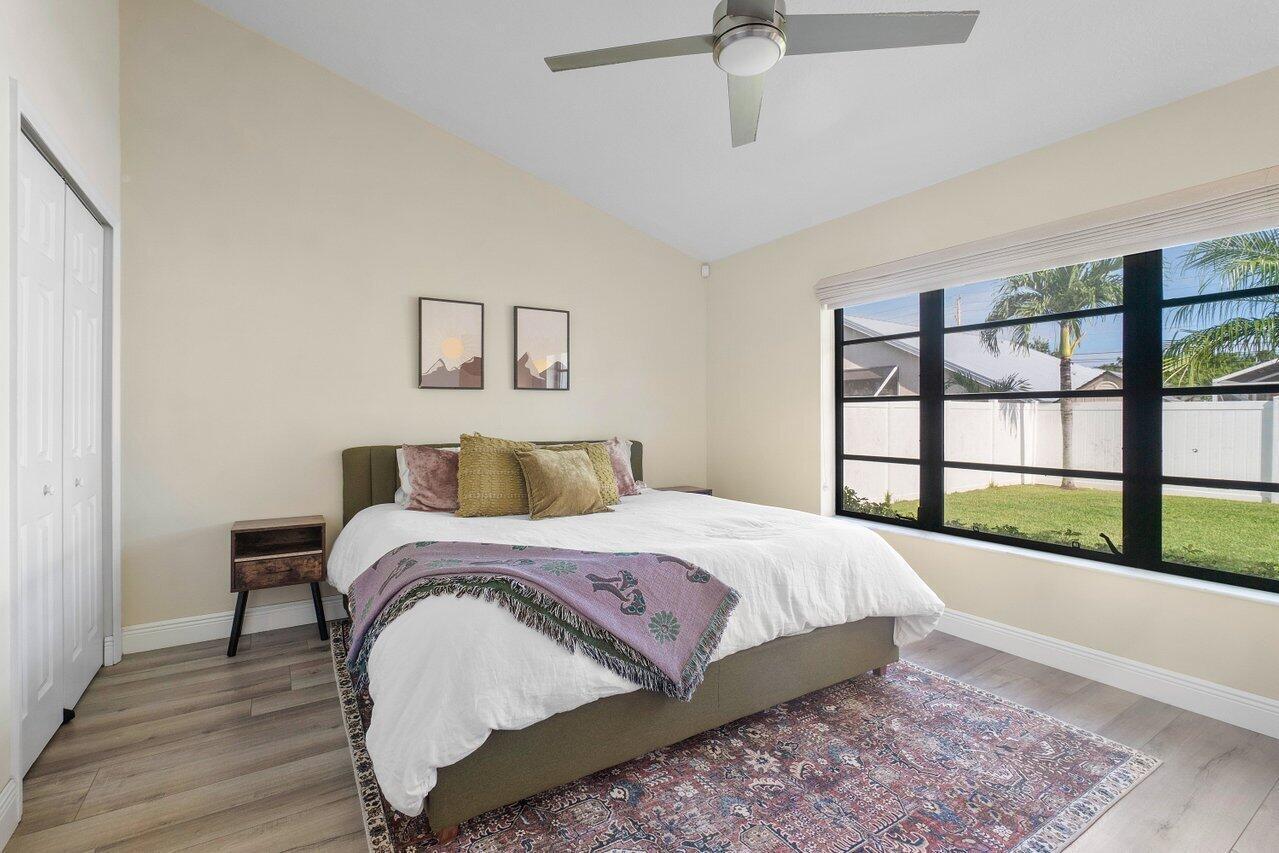 6085 Robinson Street Jupiter, FL 33458 - Photo 17 of 32 a bedroom with a large bed and a large window