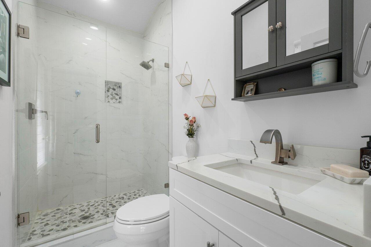 6085 Robinson Street Jupiter, FL 33458 - Photo 21 of 32 a bathroom with a sink a toilet and shower
