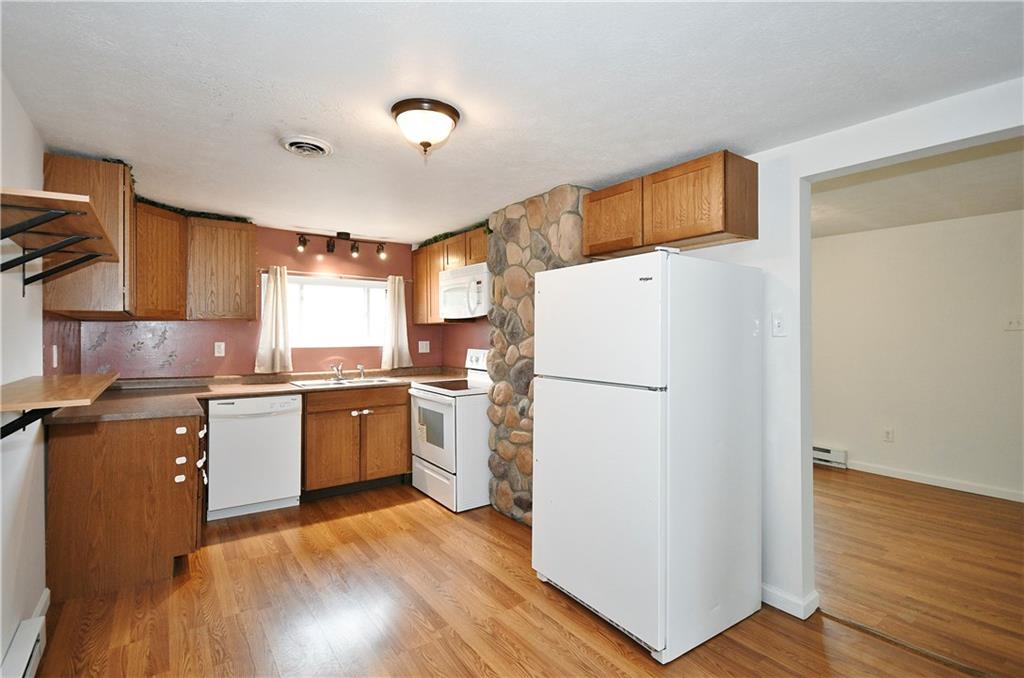 66 Chestnut Street Ellsworth, PA 15331 - Photo 14 of 28 a kitchen with a refrigerator a stove top oven a sink and wooden floor