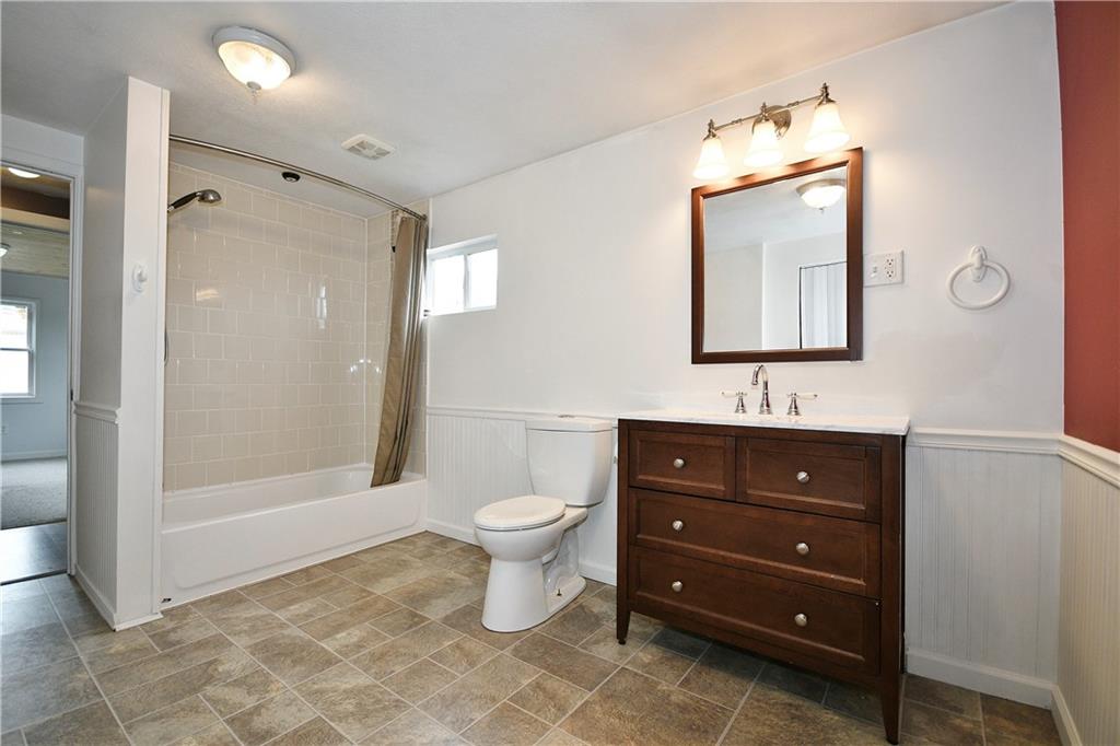 66 Chestnut Street Ellsworth, PA 15331 - Photo 15 of 28 a bathroom with a toilet a sink a mirror and shower