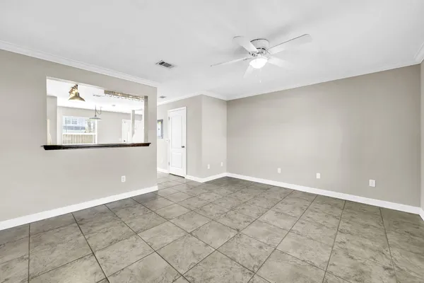 an empty room with windows and fan