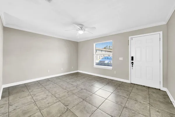 an empty room with windows and ceiling fan