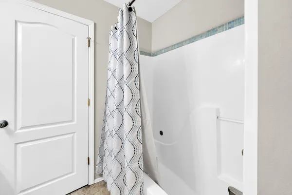 an empty room with windows and ceiling fan