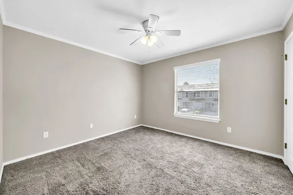 an empty room with a ceiling fan and a window