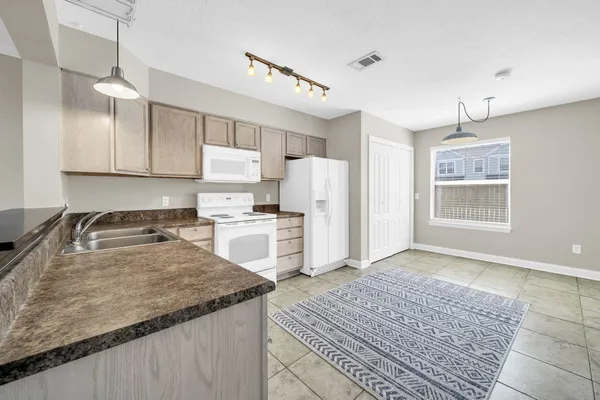 a kitchen with white cabinets and white appliances