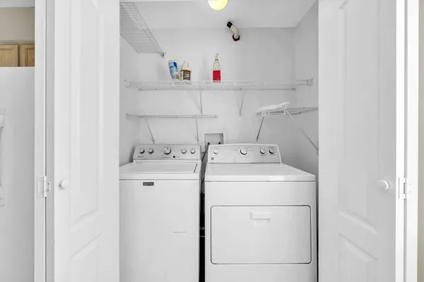 a view of a hallway with wooden floor and a living room