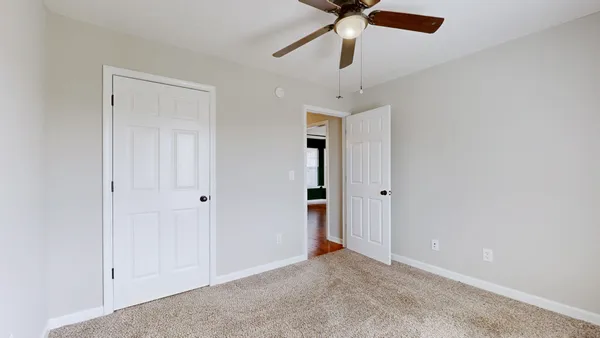 an empty room with a window and a fan