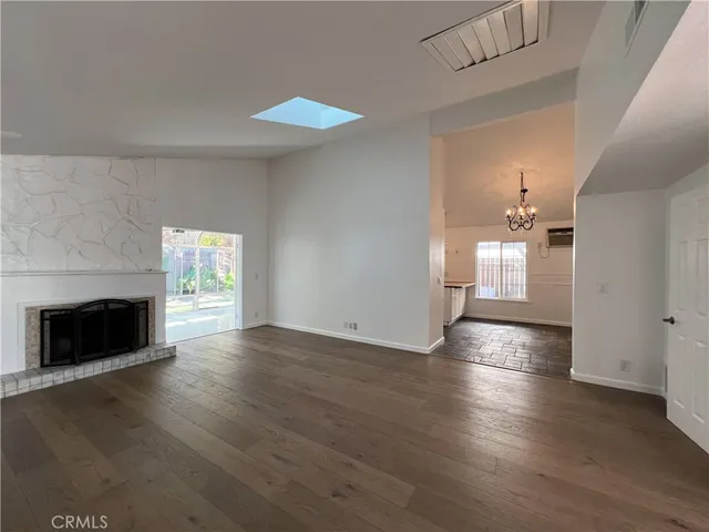 a view of a livingroom with wooden floor and a fireplace
