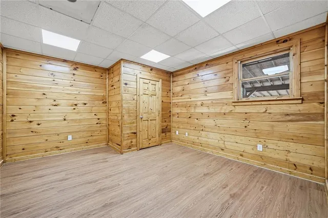 a view of a small house with a small yard and wooden fence