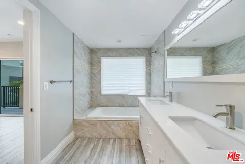 a bathroom with a tub sink and window
