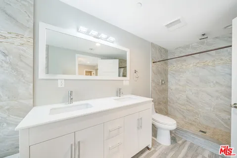 a bathroom with a sink a toilet and shower