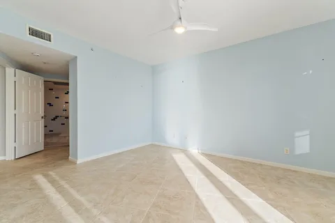 a view of a room with a ceiling fan and window