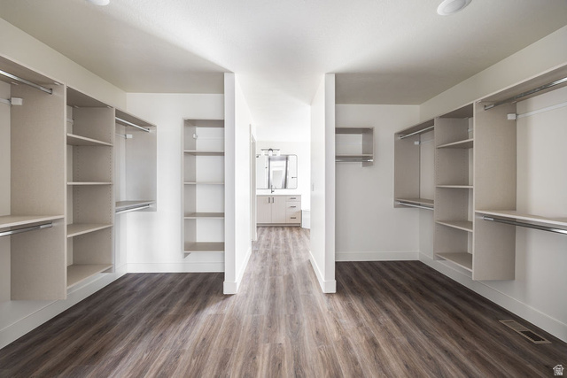 3308 South 1000 West Logan, UT 84321 - Photo 13 of 30 Walk-in closet with extensive built-in shelving, hanging rods, and wood-finish flooring