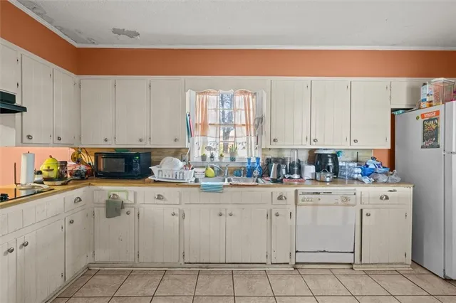 a kitchen with white cabinets and white appliances