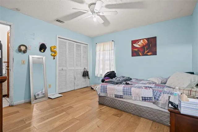 a bedroom with a bed and wooden floor