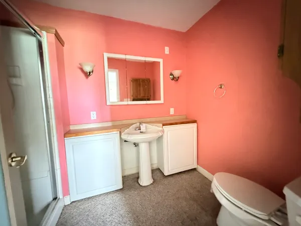 a bathroom with a sink a toilet and mirror