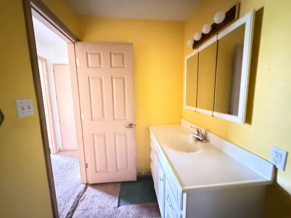 a bathroom with a tub sink and mirror