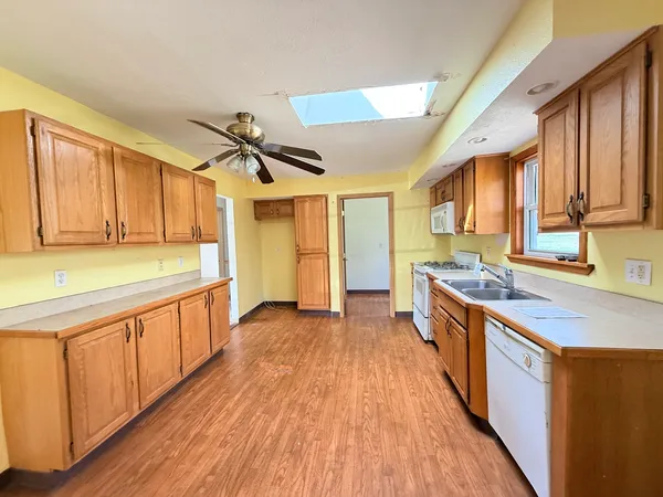 a large kitchen with stainless steel appliances granite countertop a lot of counter space and wooden floors