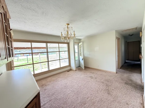 an empty room with chandelier and windows