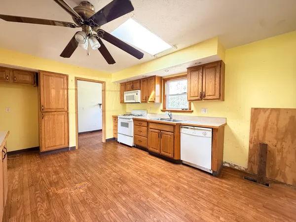 a view of a kitchen with wooden floor and electronic appliances
