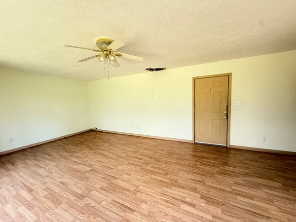 a view of a room with wooden floor and a ceiling fan