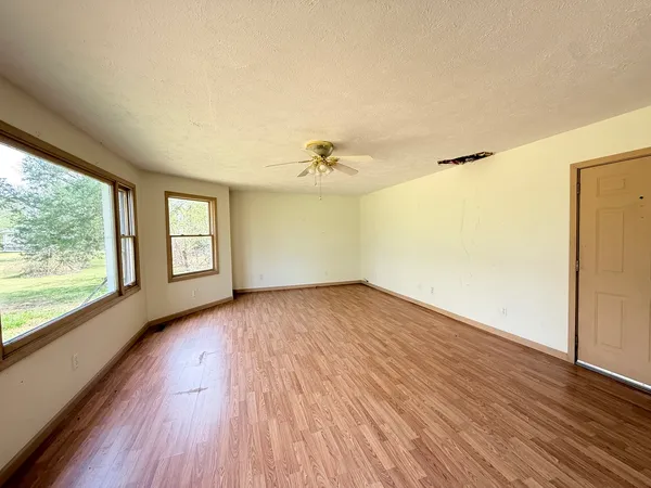 a view of a room with wooden floor and a window