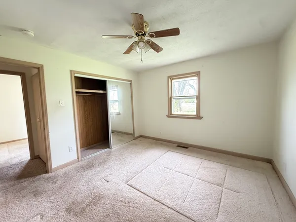 an empty room with windows and closet