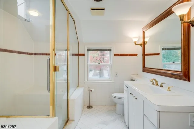 a bathroom with a sink toilet and shower a mirror