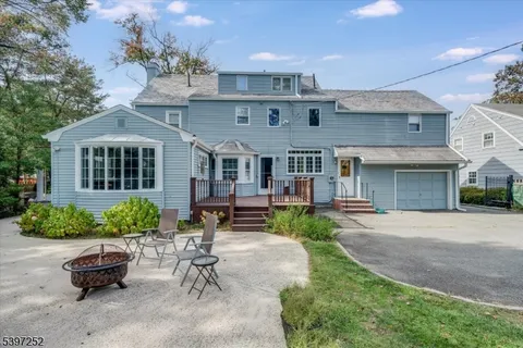 a view of a patio with couches table and chairs potted plants and large tree