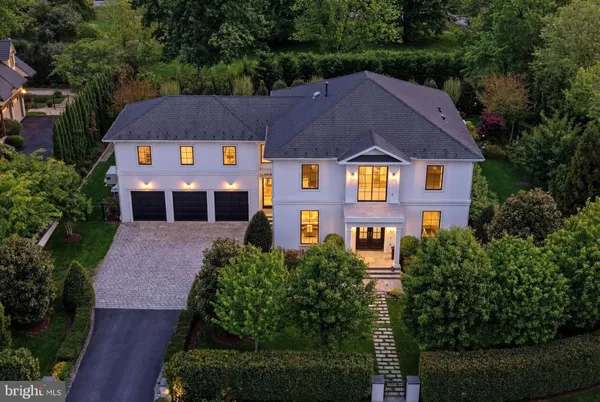 a aerial view of a house with a yard and large trees