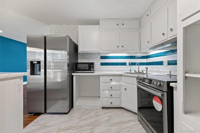 a kitchen with stainless steel appliances granite countertop a refrigerator and a stove