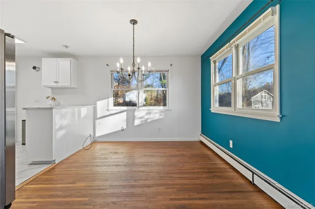 a view of a kitchen with kitchen island stainless steel appliances wooden floor and window