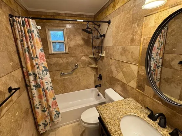 a bathroom with a granite countertop toilet sink and mirror