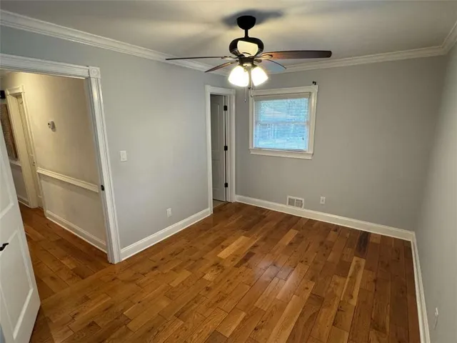a view of an empty room with a chandelier fan