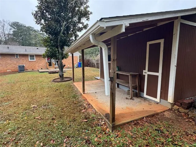 a view of a house with backyard and trees