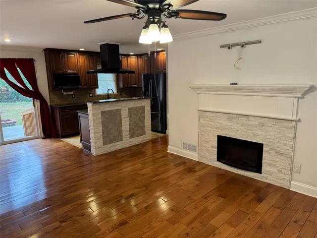 a view of kitchen with a fireplace and wooden floor