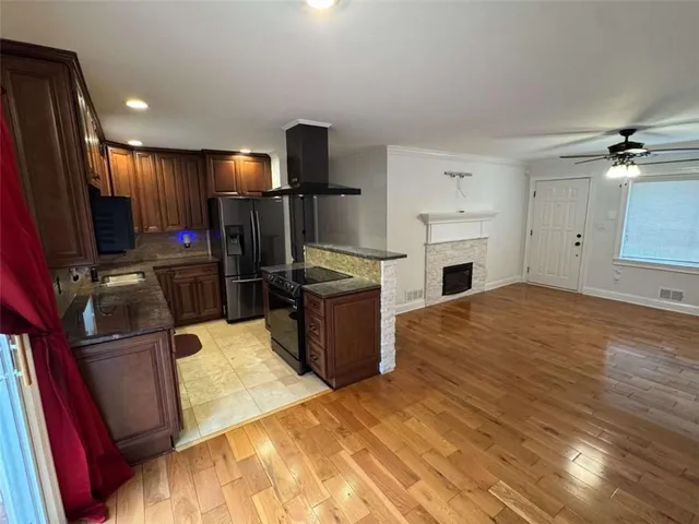 a open kitchen with refrigerator stove and wooden floor