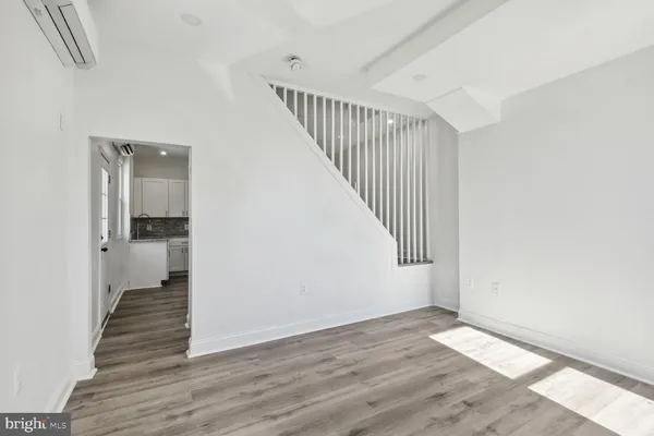 a view of a hallway with wooden floor and entryway