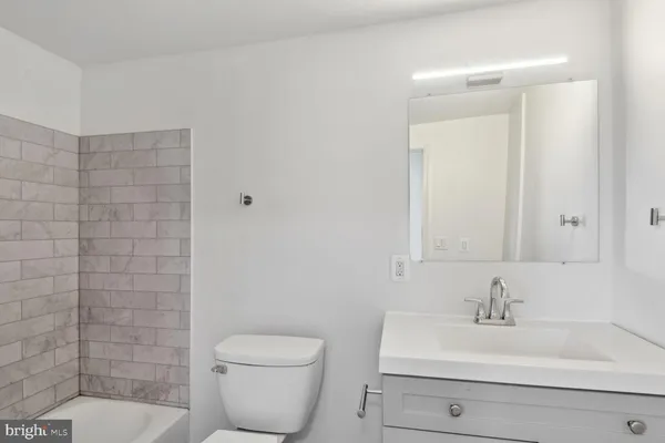 a bathroom with a sink a toilet and mirror