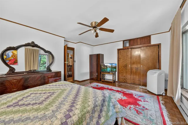 a bedroom with a bed a mirror on dresser and a large mirror