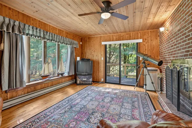 wooden floor in an empty room with a fireplace and a window