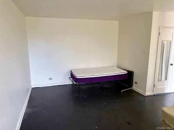 a room with a bed and wooden floor