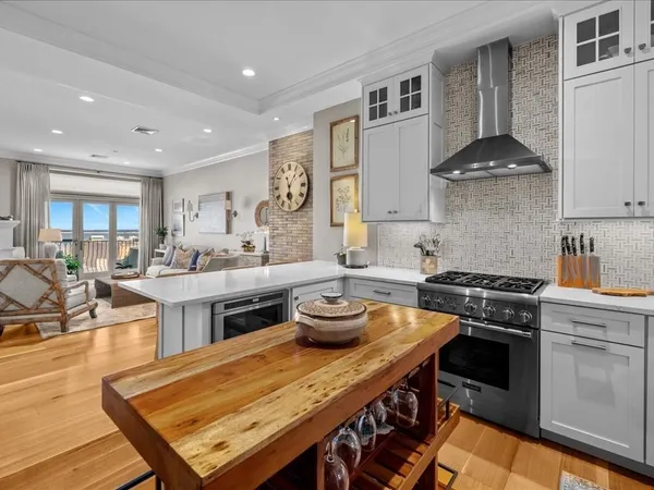 a kitchen with stainless steel appliances granite countertop a stove a sink dishwasher and cabinets with wooden floor