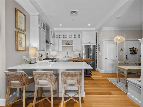 a kitchen with stainless steel appliances granite countertop a table chairs sink and cabinets