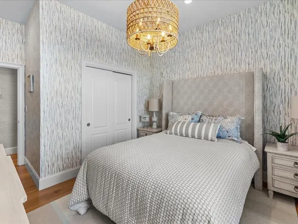 a bedroom with a bed and a chandelier