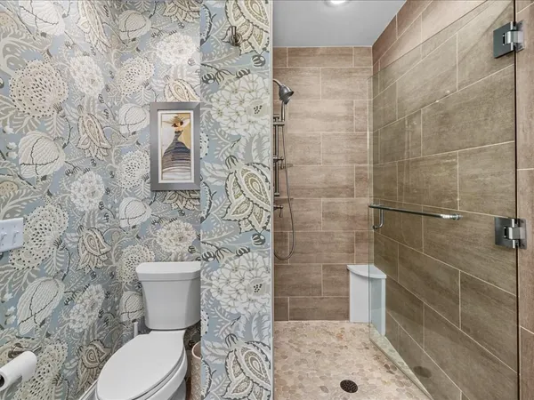 a bathroom with a toilet and a shower